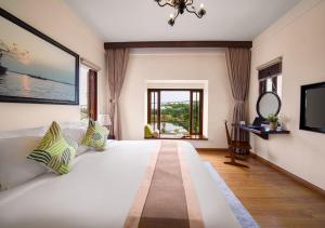 a bedroom with a large white bed and a window at Faifo Boutique Hotel & Spa in Thanh Ðông (1)