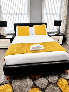 a bedroom with a large bed with yellow pillows at B&G Homes in Hollinwood