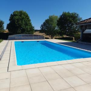 a swimming pool with blue water in a yard at Lahitte in Saint-Frajou