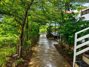 a path with trees and a white fence at Royal Villa Resort in Sāngli