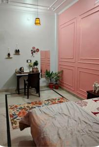 a bedroom with a pink door and a desk at Whispring hills hotel in Sodākor