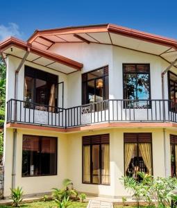 a house with a balcony on top of it at Freedom Rest Rooms in Anuradhapura