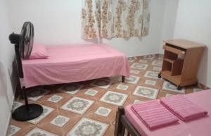 a room with a pink bed and a table and a floor at Freedom Rest Rooms in Anuradhapura