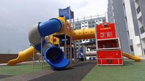 a playground with a slide in front of a building at Riverfront Homestay at Ambience Residence in Malacca