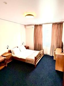 ein Hotelzimmer mit einem Bett und einem Fenster in der Unterkunft Okolytsya in Riwne