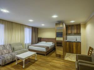 a hotel room with a bed and a couch at Hotel Iveria in Abastumani
