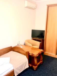ein Hotelzimmer mit Schreibtisch und Bett und einem Schreibtischictericter in der Unterkunft Okolytsya in Riwne + 11 Fotos