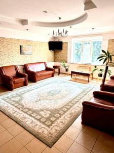 ein Wohnzimmer mit Ledermöbeln und einem Teppich in der Unterkunft Okolytsya in Riwne