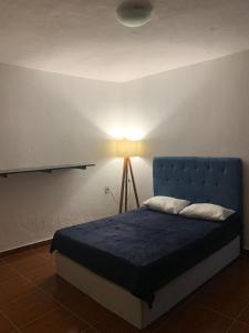 a bed with a blue headboard in a room at Sobiuai 72 in Ouro Preto