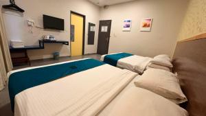 a hospital room with two beds and a tv at Hotel Bestari in Kuala Lipis