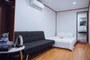 a living room with a couch and a bed at Thái house Mộc Châu in Bản Chiềng Di