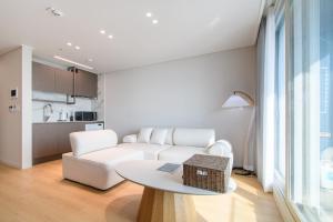 a living room with a white couch and a table at 플럼바고올스위트402 in Chosan-ni