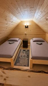 a room with two beds in a wooden cabin at Карпатські Мандри in Verkhovyna