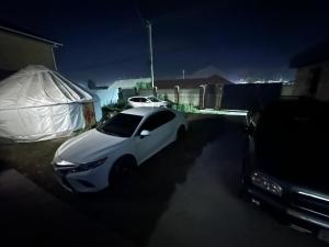 a white car parked in a parking lot at night at Tunduk house in Naryn