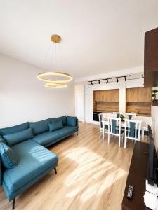 a living room with a blue couch and a table at Green Terrace Square View in Tirana
