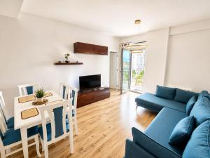 a living room with a blue couch and a table at Green Terrace Square View in Tirana
