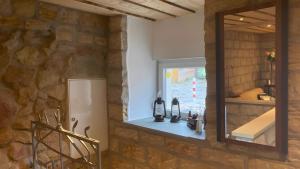 a bathroom with a mirror and a stone wall at Ferienwohnung Für 4 Personen 90 M² in Naumburg +9 photos