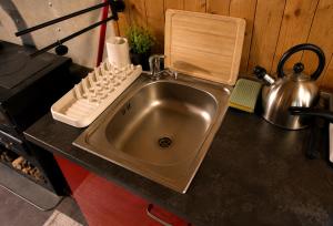 a kitchen sink with a cutting board on top of it at Maringotka MIMO in Uhelná