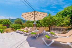 a group of chairs and an umbrella on a patio at Casa Margarita in Andratx