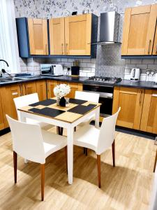 a kitchen with a white table and white chairs at B&G Homes in Hollinwood +17 photos