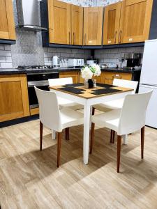 a kitchen with a white table and white chairs at B&G Homes in Hollinwood