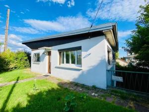 a small white house with a grass yard at La Maison Bloom in Houilles