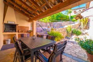 eine Terrasse mit einem Holztisch und Stühlen in der Unterkunft Cal Tio in Caimari