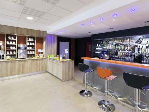 a bar in a hotel with chairs and a counter at ibis Styles Flers in Flers