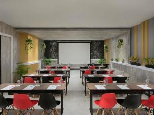 a restaurant with tables and red chairs and a whiteboard at ibis Bangkok IMPACT in Nonthaburi