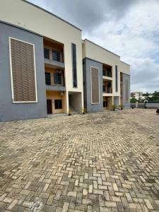 a large building with a brick courtyard at Nouveau Apartment in Abuja