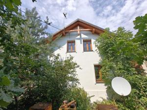 a white house with a wooden roof at Agroturystyka - Pasieka Miody Gór Opawskich in Dobiesźow
