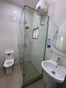 a bathroom with a shower and a toilet and a sink at Nouveau Apartment in Abuja +58 photos