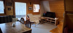 a living room with a table and a television at Vikendica Luna in Gornja Šišava