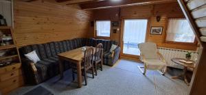 a living room with a couch and a table and chairs at Vikendica Luna in Gornja Šišava