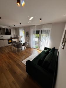 a living room with a black couch and a table at Apartament ul Jodłowa Malinka in Opole