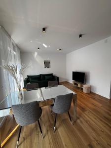 a living room with a table and chairs and a couch at Apartament ul Jodłowa Malinka in Opole