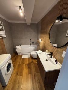 a bathroom with a sink and a washing machine at Apartament ul Jodłowa Malinka in Opole