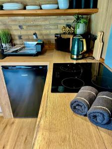 a kitchen with a counter with a stove top oven at Arts Hollow in Binegar