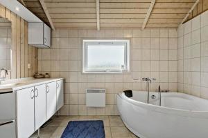 a bathroom with a tub and a sink and a window at 7323-Bogo-Vindrosen-23 in Gammelby +21 photos