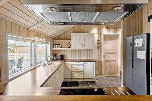 a kitchen with white cabinets and a refrigerator at 7323-Bogo-Vindrosen-23 in Gammelby
