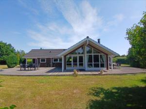 a house with a large deck with a large glass door at 7323-Bogo-Vindrosen-23 in Gammelby