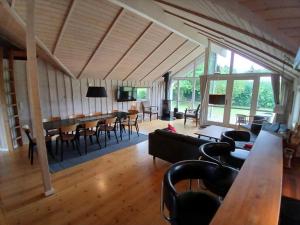a living room with a couch and a table and chairs at 7323-Bogo-Vindrosen-23 in Gammelby