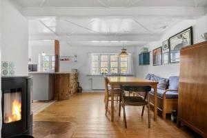 a living room with a table and a fireplace at R530-Store-Heddinge-Straedet-10 in Holtug