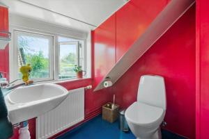 a bathroom with a white sink and a red wall at R530-Store-Heddinge-Straedet-10 in Holtug +22 photos