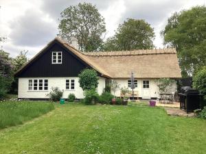 a white house with a black roof and a yard at R530-Store-Heddinge-Straedet-10 in Holtug