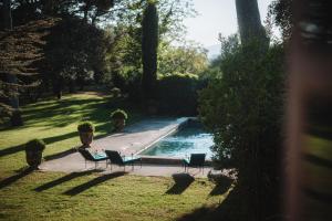 a swimming pool in a yard with chairs next to it at Haras de Castellane in Pertuis