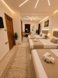 a bedroom with two beds and a living room at panorama pyramids and jacuzzi in Giza