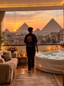 a man walking into a bath tub in a room with pyramids at panorama pyramids and jacuzzi in Giza