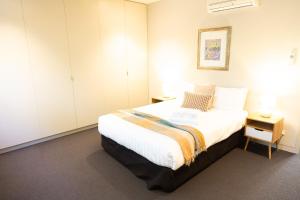 a bedroom with a large bed with white walls at Emanjay - Mineral Spa, Million Dollar Views in Mount Martha +24 photos