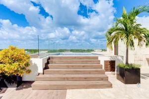 a set of stairs leading to a pool with a palm tree at Eight Condos Multi Listing in Playa del Carmen